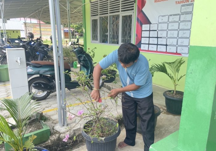 Petugas kebersihan dan ASN Madrasah Bersih-Bersih Halaman Sabtu Pagi
